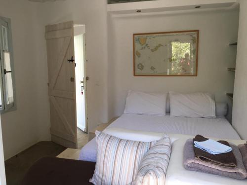 a bedroom with a white bed with towels on it at Red Tractor Farm in Korissia