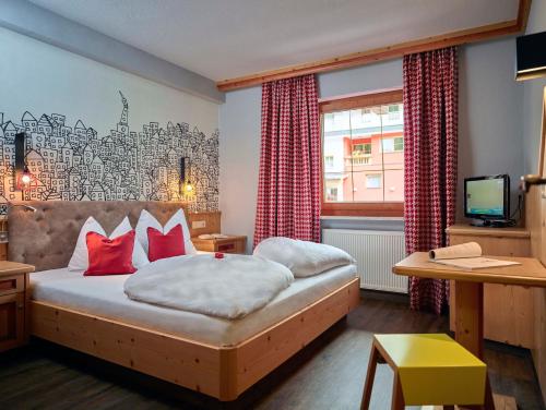 ゲルロスにあるGerlosperleの赤い枕のベッドが備わるホテルルームです。