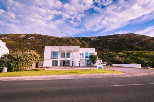 a white house on the side of a road at Agulhas Ocean House in Agulhas