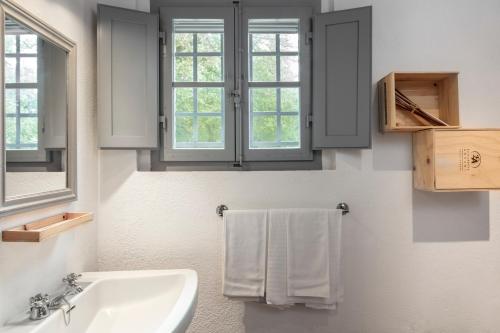 a bathroom with a sink and two windows and towels at Tenuta della Selva in Murlo