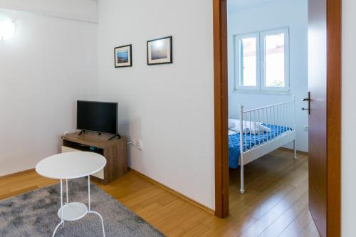 a room with a table and a bed and a mirror at Apartman Emil in Supetar