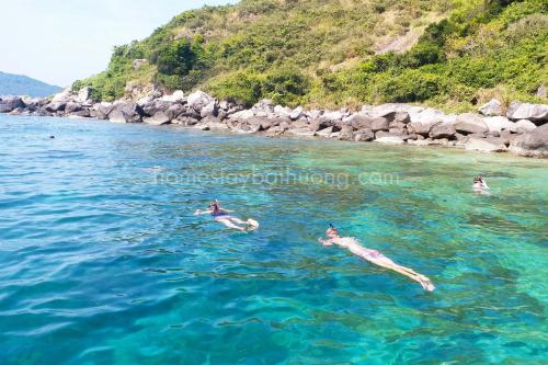 a group of people swimming in the water at Nhi Lo Home Stay in Tân Hiệp