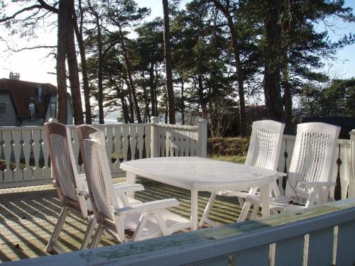 a white table and four chairs on a deck at Villa Lullyhill in Visby