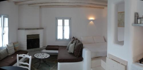 a white living room with a couch and a fireplace at Red Tractor Farm in Korissia