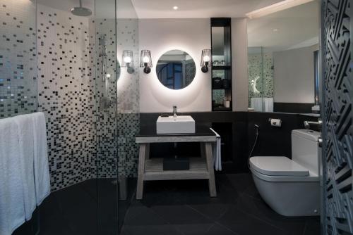 a bathroom with a sink and a toilet and a mirror at Hard Rock Hotel Bali in Kuta