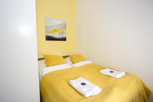 ニュルンベルクにあるFerienwohnung Nürnberg, nahe U-Bahnのベッドルーム1室(黄色いベッド1台、タオル付)