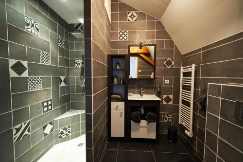 a bathroom with a sink and a tile wall at Chateau De La Moriniere in Beaupréau