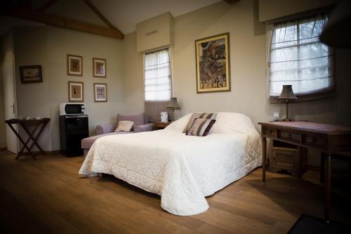 a bedroom with a white bed and a table and window at Chateau De La Moriniere in Beaupréau