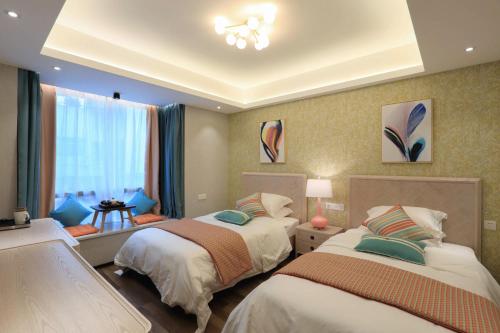 a bedroom with two beds and a window at Li River Resort Villa Hotel in Guilin