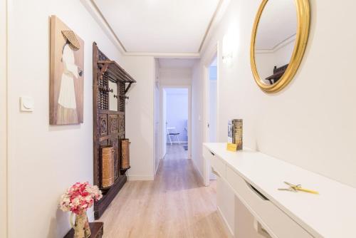 La salle de bains blanche est pourvue d'un miroir et d'un lavabo. dans l'établissement Zurriola - Beachside Comfort, à Saint-Sébastien