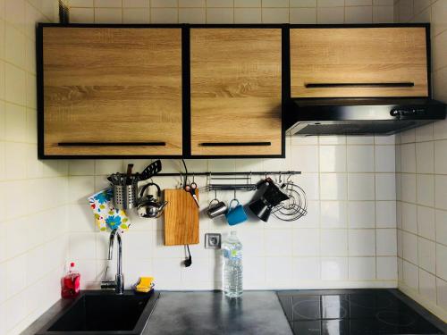 a kitchen with wooden cabinets and a sink at Week-end Porte de Clichy in Clichy