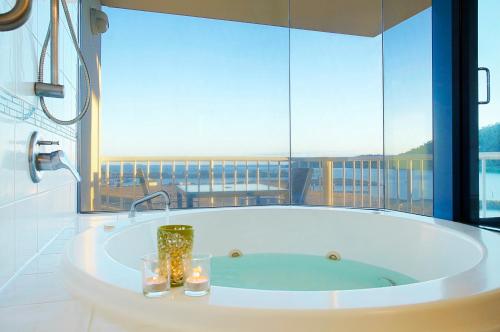 a bath tub in a bathroom with a large window at at Whitsunday Vista Holiday Apartments in Airlie Beach