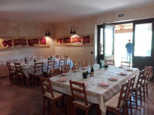 ein großes Esszimmer mit einem langen Tisch und Stühlen in der Unterkunft Il Casale della Biodiversità in Scanzano