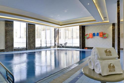 a large swimming pool with a chair in a building at Golden dune Hotel Services-Turaif in Ţurayf