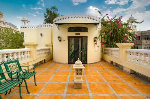 a house with a porch with a green bench at Hotel Sugan Niwas Palace in Jaipur