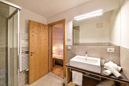 bagno con lavandino e specchio di Schäfer Apartments a Sesto