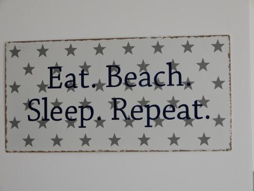 a sign that says eat beach sleep sleep repeat at Summer apartment in Bar