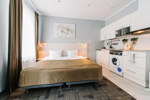 a bedroom with a bed and a washing machine at Apartments Statskij Sovetnik in Saint Petersburg