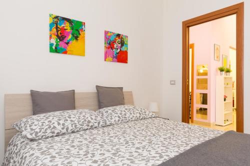 a bedroom with a bed and two pictures on the wall at Apartament Ciraulo in Catania