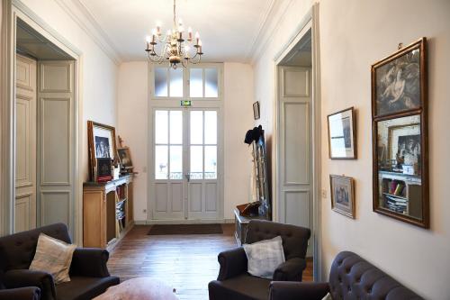a living room with chairs and a chandelier at Chateau De La Moriniere in Beaupréau
