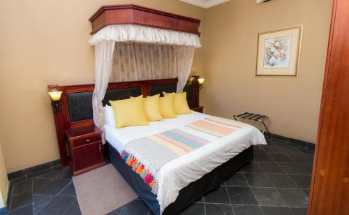 a bedroom with a bed with a canopy at Picanha Grill Guest House & Events Venue in Nigel