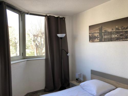 une chambre avec un lit et une fenêtre dans l'établissement Vacances Cannoise, mer et piscine, à Cannes