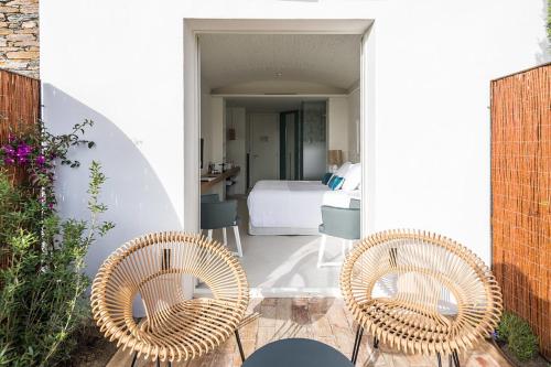 two wicker chairs sitting on a patio with a bedroom at Boutique Hotel Villa Gala by Fimedhotels in Cadaqués