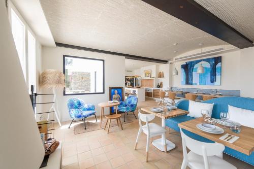 Boutique Hotel Villa Gala في كاداكيس: غرفة معيشة مع كراسي زرقاء وغرفة طعام