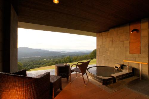 a room with a table and chairs and a large window at Akakura Kanko Hotel in Myoko