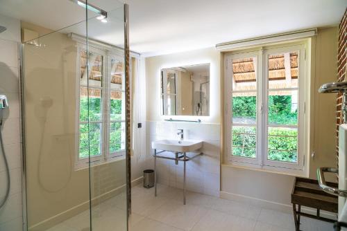 オンフルールにあるNew Cottage & spa de nage Guesthouseのバスルーム(洗面台、ガラス張りのシャワー付)