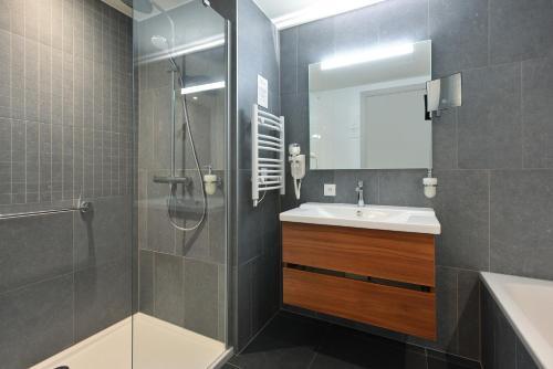 a bathroom with a shower and a sink at Martin's All Suites in Louvain-la-Neuve