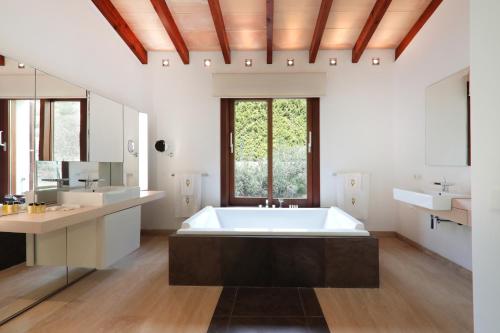 een badkamer met een groot bad en 2 wastafels bij Villa Amber by Cap Vermell Estate in Canyamel