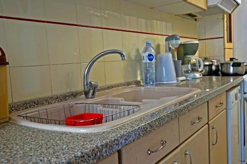 a kitchen sink with a red bowl in it at Villa Fofo - Beautiful Sea Front Villa with 650m2 garden in Nea Kalikratia