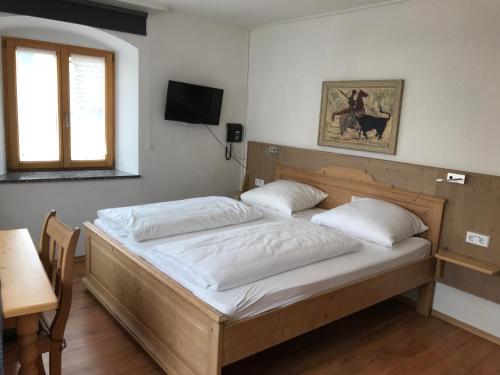 2 camas en una habitación con mesa y ventana en Gasthof Stern, en Greding