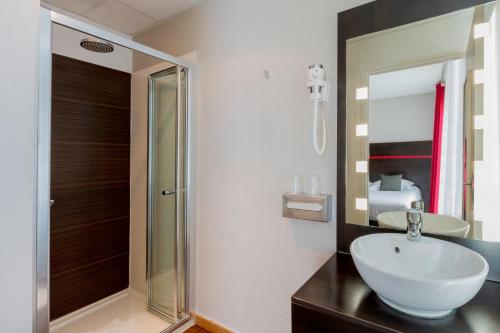 a bathroom with a sink and a glass shower at Best Western Urban Hotel in Lille