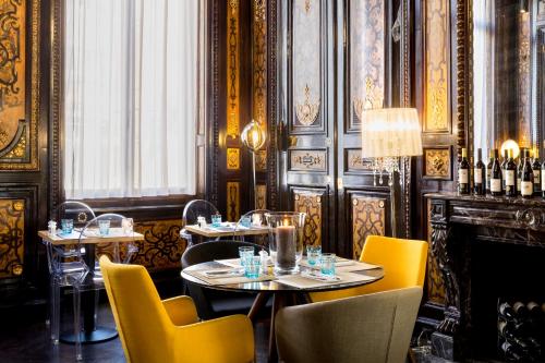 a restaurant with tables and chairs and bottles of wine at Best Western Urban Hotel in Lille