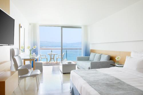 um quarto de hotel com uma cama e uma sala de estar em Lindos Blu Luxury Hotel-Adults only em Lindos