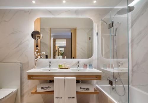 a bathroom with a sink and a shower and a mirror at Barceló Cáceres V Centenario in Cáceres