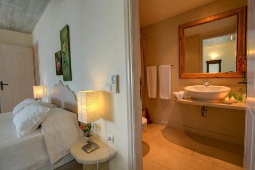 a bathroom with a bed and a sink and a mirror at Ideales Resort in Trapezaki