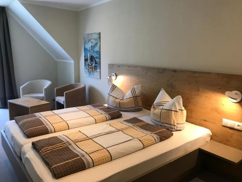 a bedroom with two beds and a chair at Weinbergs Loge in Ernst