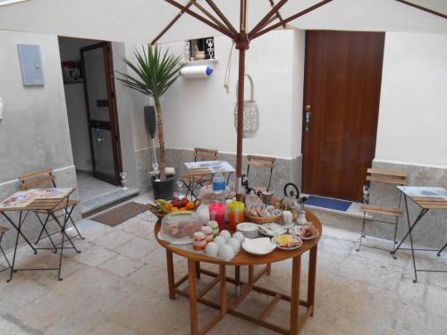 una mesa con comida en una habitación en La Corte Dei Naviganti, en Trapani