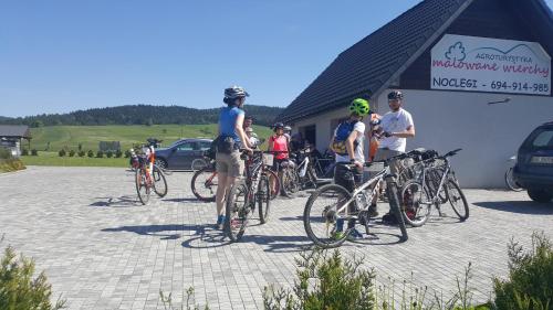 grupa ludzi stojących obok swoich rowerów w obiekcie Malowane Wierchy w mieście Gładyszów