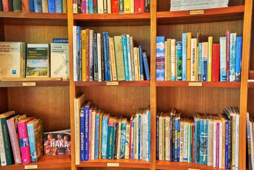 a book shelf filled with lots of books at Cabot Lodge - Fiordland National Park in Manapouri