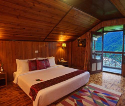 a bedroom with a large bed and a large window at Club Mahindra Gangtok in Gangtok