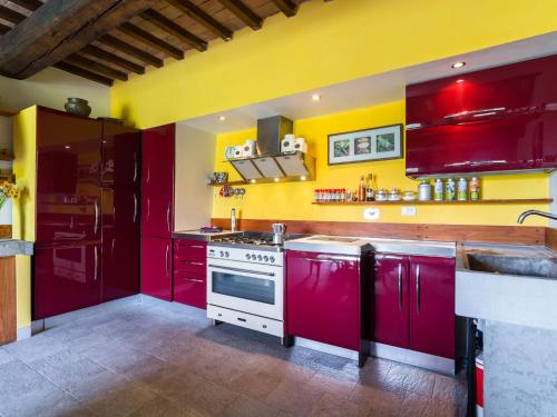 VitoliniにあるExotic Holiday Home in Vinci with Swimming Poolの赤いキャビネットと黄色い壁のキッチン