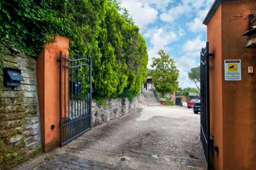 an alley with a gate and a stone wall at Villalbert in Castel Gandolfo
