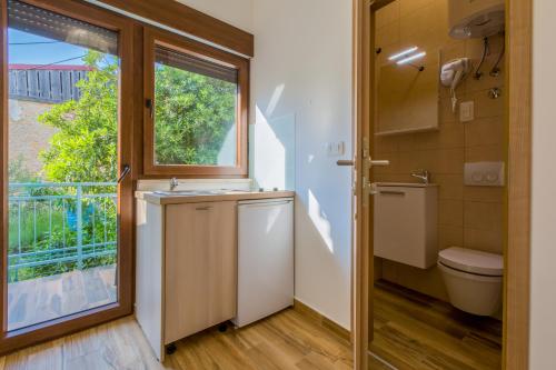 a bathroom with a toilet and a window at Beach Apartments Center in Crikvenica