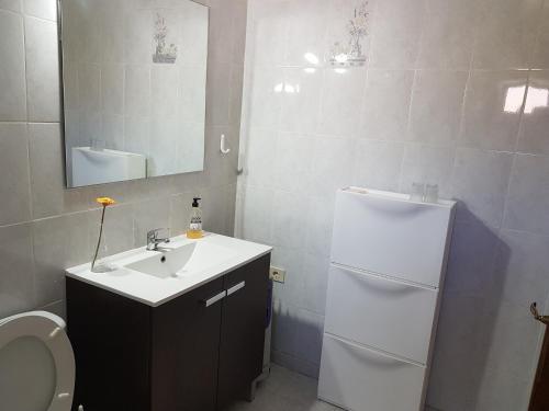 a bathroom with a sink and a white refrigerator at Casa Kiko in Playa de Santiago