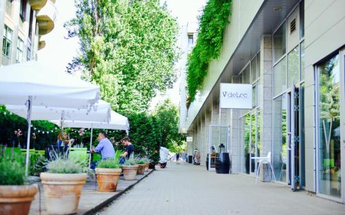 chodnik z roślinami i parasolami przed budynkiem w obiekcie JessApart – Ochota Apartments w Warszawie