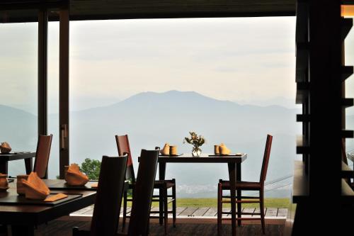 a dining room with a table and chairs and a large window at Akakura Kanko Hotel in Myoko